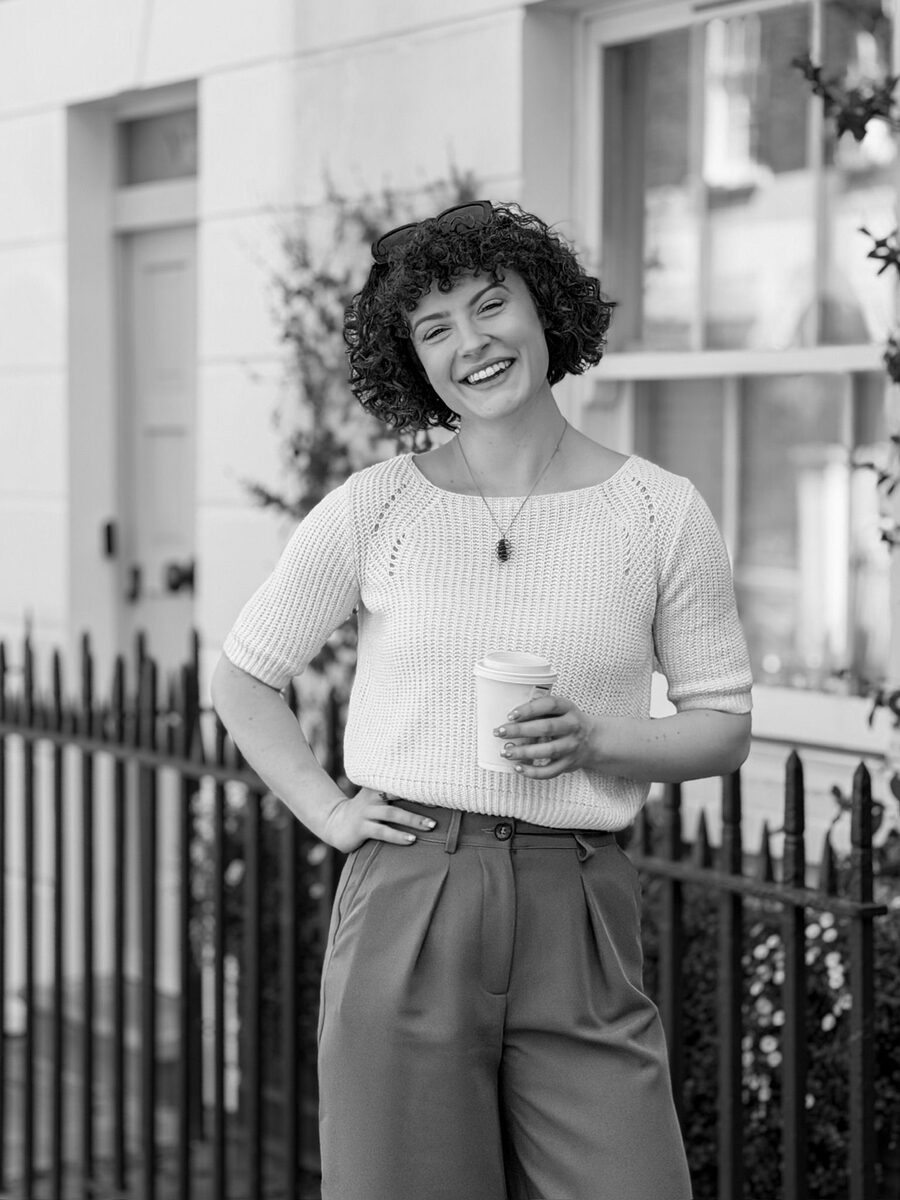 Hannah Crawford, business coach, smiling outdoors with a coffee